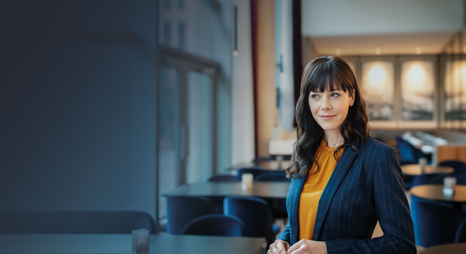 A business Woman in the lobby of a hotel with a smiling face